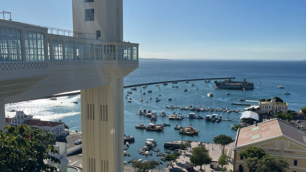 Vista panorâmica do Elevador Lacerda em Salvador, mostrando a Baía de Todos os Santos e o Mercado Modelo ao fundo, destaque do turismo no Centro Histórico de Salvador Bahia.